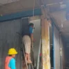 Pekerja sedang memperbaiki pintu besi yang sempat terkena api untuk bisa difungsikan kembali, Kamis (13/3/2025). (Fatkhur Rizqi/Radar Tasikmalaya)