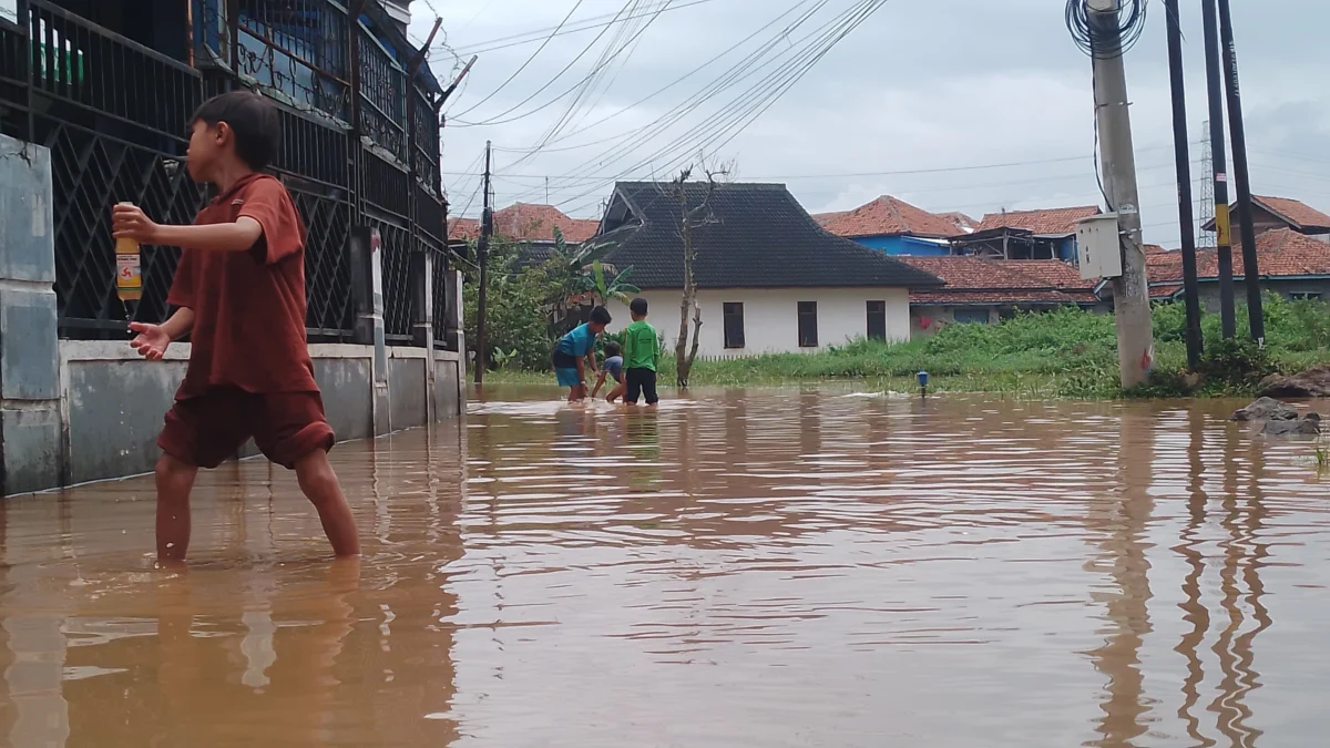 Anak-anak sedang bermain air di gedangan banjir wilayah Desa Cihanjuang, Kecamatan Cimanggung, Kabupaten Sumedang. (Yanuar Baswata/Jabar Ekspres)
