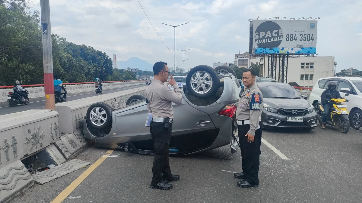 Dik. Kendaraan roda empat jenis Honda Brio terbalik usai dihantam pickup di Flyover Pasoepati Bandung. Sabtu (22/3). Foto. Sandi Nugraha.