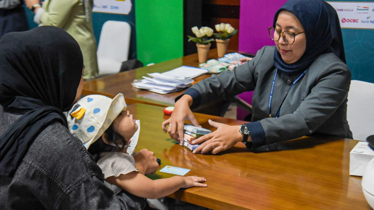 Petugas memberikan uang rupiah kertas terbaru kepada warga saat penukaran di Masjid Pusdai, Kota Bandung, Senin (24/3). Foto: Dimas Rachmatsyah / Jabar Ekspres