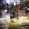 Seorang pengendara motor melintasi jalan yang tergenang banjir di Ciwastra, Kota Bandung, Jumat (7/3). Foto: Dimas Rachmatsyah / Jabar Ekspres