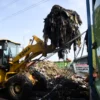 Pekerja menggoperasikan alat berat membersihkan tumpukan sampah di Pasar Induk Gedebage, Kota Bandung, Senin (28/4). Foto: Dimas Rachmatsyah / Jabar Ekspres