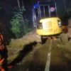 Nampak petugas menggunakan alat berat untuk membersihkan material longsor yang menutupi jalan di wilayah Desa Neglasari Kecamatan Pamarican Kabupaten Ciamis, Rabu 2 April 2025 malam. (Istimewa)