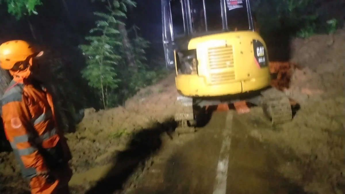 Nampak petugas menggunakan alat berat untuk membersihkan material longsor yang menutupi jalan di wilayah Desa Neglasari Kecamatan Pamarican Kabupaten Ciamis, Rabu 2 April 2025 malam. (Istimewa)
