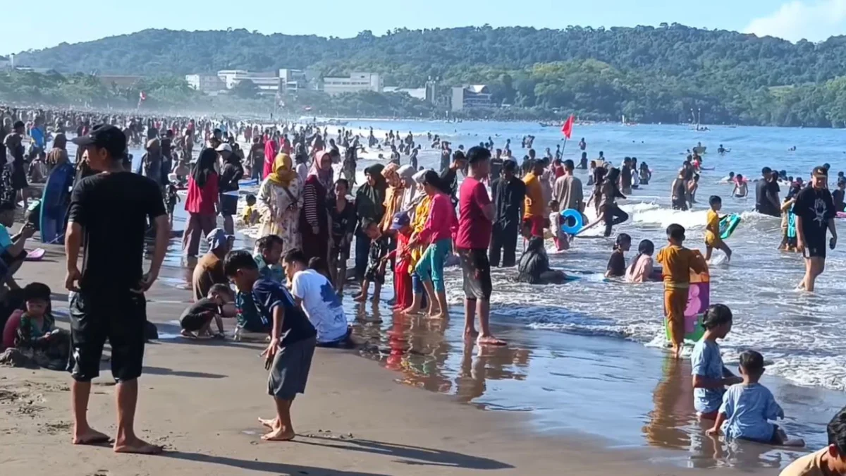 Ribuan wisatawan tumpah di bibir pantai Pangandaran, Kamis 3 April 2025. Pantai Pangandaran masih menjadi favorit wisatawan untuk mengisi libur lebaran. (Cecep Herdi/Jabar Ekspres)