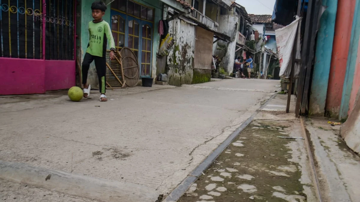 Seorang anak bermain di samping jalur rel kereta api Bandung - Ciwidey yang saat ini telah dibangun rumah warga di Jalan Babakan Deki, Desa Citeureup, Kecamatan Dayeuhkolot, Kabupaten Bandung, Rabu (23/4). Foto: Dimas Rachmatsyah / Jabar Ekspres