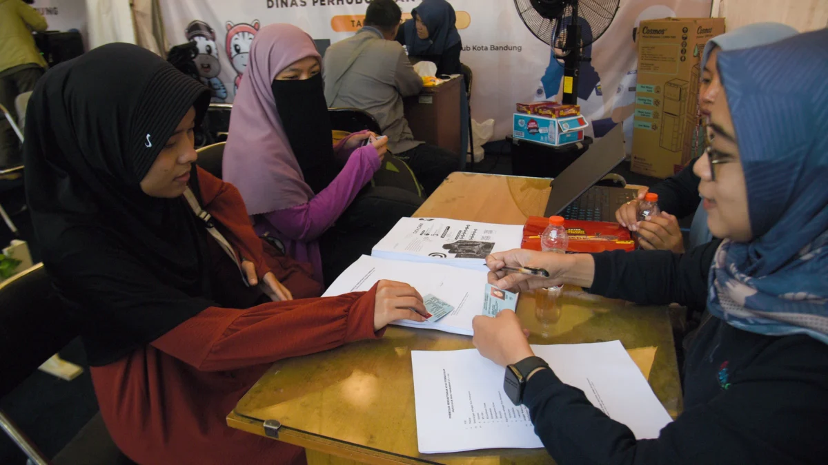Petugas Dinas Kependudukan Dan Pencatatan Sipil (Disdukcakpil) Kota Bandung memeriksa dokumen kependudukan berupa KTP penumpang yang baru tiba di Terminal Cicaheum, Kota Bandung, Senin (7/4). Foto: Dimas Rachmatsyah / Jabar Ekspres