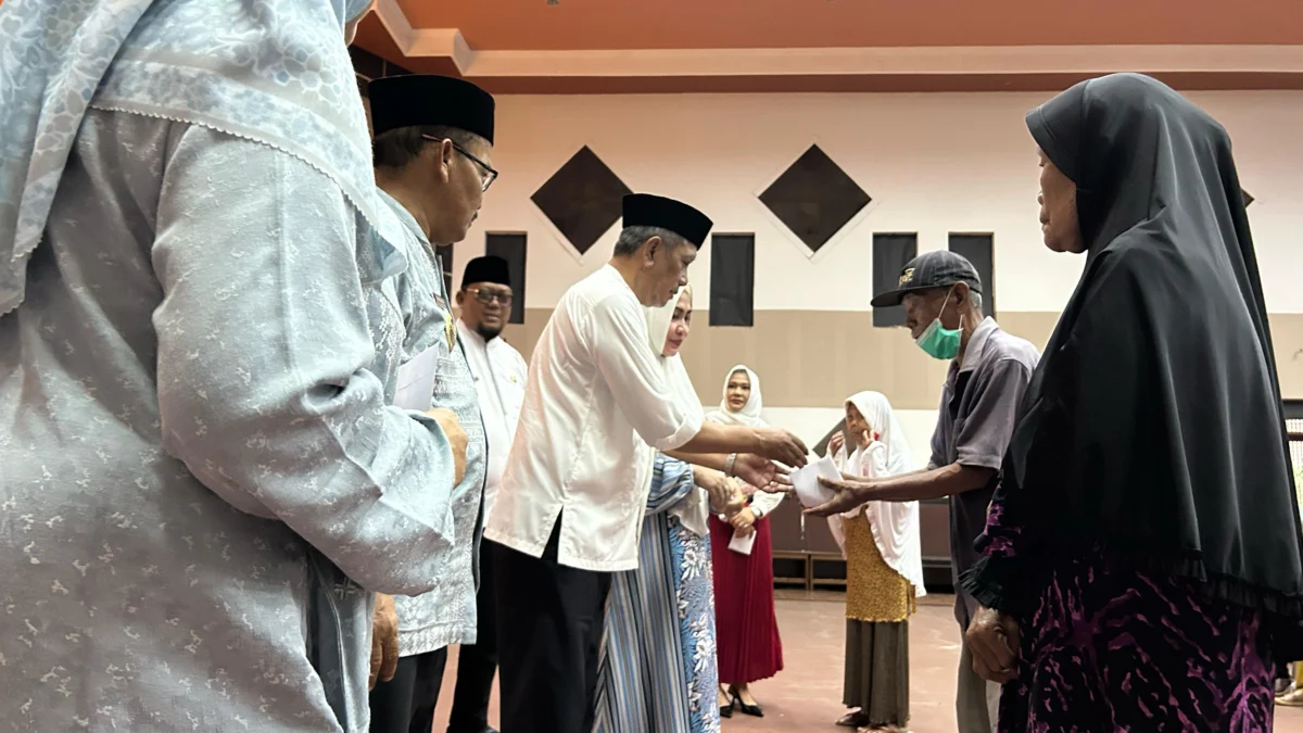 Wali Kota Banjar H Sudarsono secara simbolis menyerahkan bantuan uang kepada 'bapa asuh' sebagai realisasi dari program Nyaah ka Indung oleh Gubernur Jabar Dedi Mulyadi, Jumat (11/4/2025). (Cecep Herdi/Jabar Ekspres)