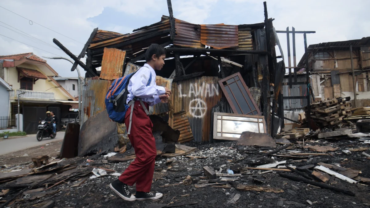 Ini Tuntutan Forum Sukahaji Melawan Pascapenyerangan Ormas! Seorang anak pulang dari sekolah di puing-puing bangunan bekas kebakaran di Gang Satata Sariksa, Sukahaji, Babakan Ciparay, Kota Bandung. Foto: Dimas Rachmatsyah / Jabar Ekspres