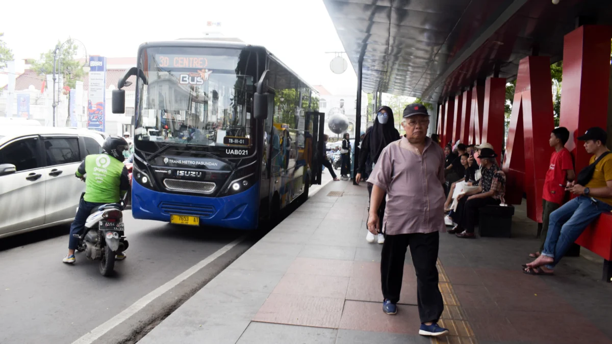 Penumpang berjalan keluar dari transportasi umum bis di Halte Alun-Alun, Jalan Asia Afrika, Kota Bandung, Senin (28/4). Foto: Dimas Rachmatsyah