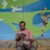 Mural Olahraga di Lodaya, Ikon Baru Bandung Selatan Seorang warga sedang membaca buku di depan mural bertema olahraga karya seniman John Martono di sepanjang tembok Sarana Olah Raga (SOR), Jalan Lodaya, Kota Bandung, Selasa (29/4). Foto: Dimas Rachmatsyah / Jabar Ekspres