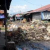 Warga berjalan di samping tumpukan sampah yang menutupi jalan di salah satu los di Pasar Induk Gedebage, Kota Bandung, Senin (28/4). Foto: Dimas Rachmatsyah / Jabar Ekspres