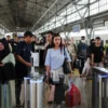 Sejumlah penumpang kereta api sedang mengantri dalam proses boarding.
