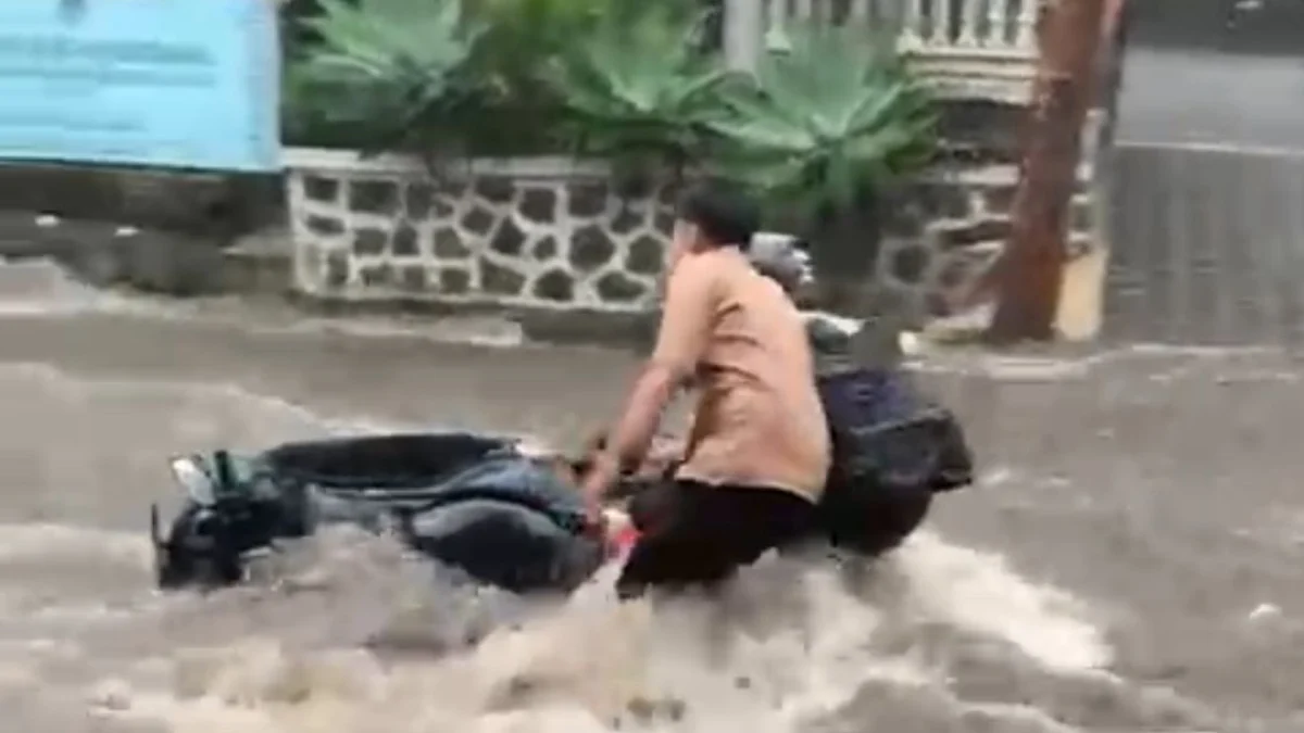 Sebuah kendaraan sepeda motor terbawa arus deras di Jalan Kayuambon, Kecamatan Lembang, KBB. Dok tangkapan layar video warga