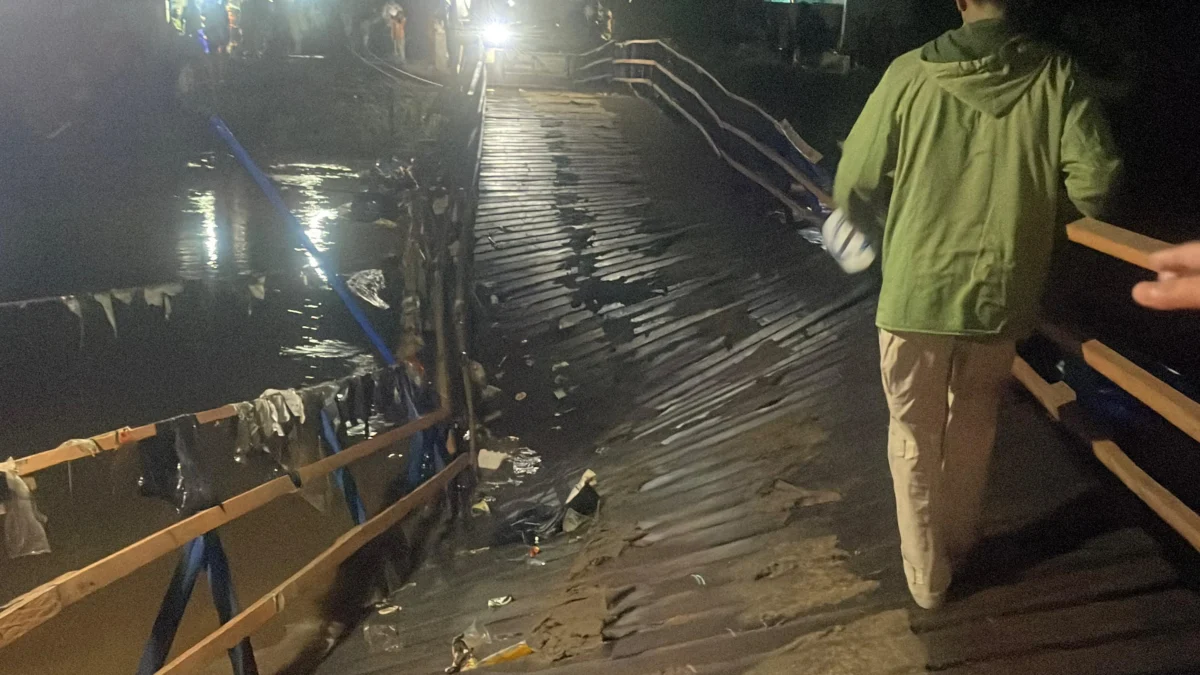 Jembatan Apung Cijeruk yang menghubungkan Kampung Cijeruk, Kecamatan Bojongsoang dengan Kampung Mekarsari, Kecamatan Baleendah, Kabupaten Bandung, patah di bagian tengah pada Jumat malam (23/5/2025) sekitar pukul 19.25 WIB. Foto Agi