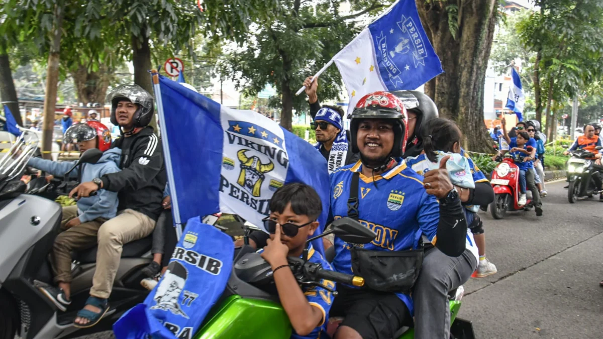 Bobotoh menggunakan motor melakukan konvoi perayaan juara liga 1 Persib Bandung di Jalan Banda, Kota Bandung, Minggu (25/5). Foto: Dimas Rachmatsyah / Jabar Ekspres