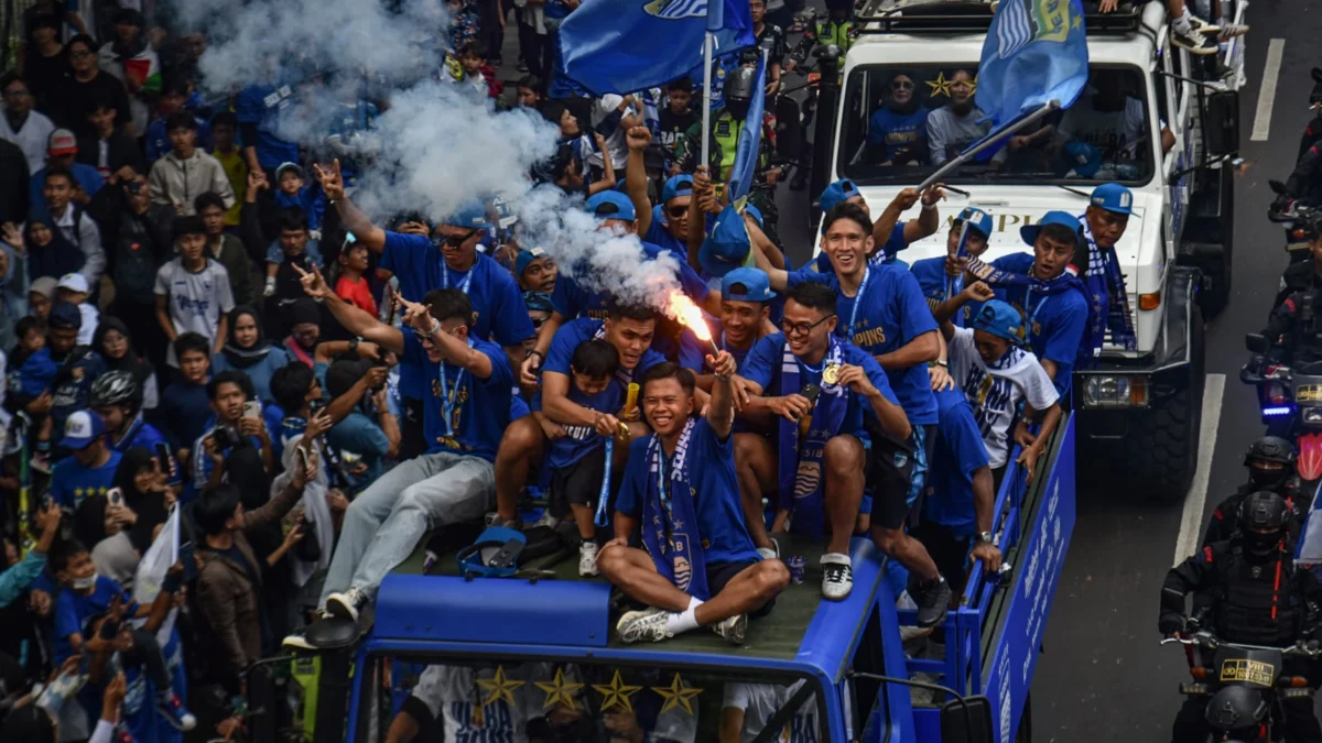 Edo Febriansah pemain Persib Bandung menyalakan suar saat pawai menaiki kendaraan Maung melintasi Jalan Wastukencana, Bandung, Minggu (25/5). Pawai Tim Persib Bandung yang diikuti ribuan warga Kota Bandung untuk merayakan gelar juara Persib Bandung Liga 1 Indonesia musim 2024-2025. Foto: Dimas Rachmatsyah / Jabar Ekspres