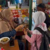Dua siswa di SD Negeri 3 Balokang Kota Banjar jajan di kanin sekolah yang dikelola Erni Jumat (2/5/2025). Erni mengaku pendapatannya menurun drastis setelah program MBG diluncurkan. (Cecep Herdi/Jabar Ekspres)