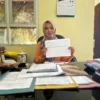 Kepala Dinsos P3A Kota Banjar, Hani Supartini, menunjukkan dokumen penerima bansos pada tahun 2023, di ruang kerjanya, Selasa (6/5/2025). (Cecep Herdi/Jabar Ekspres)