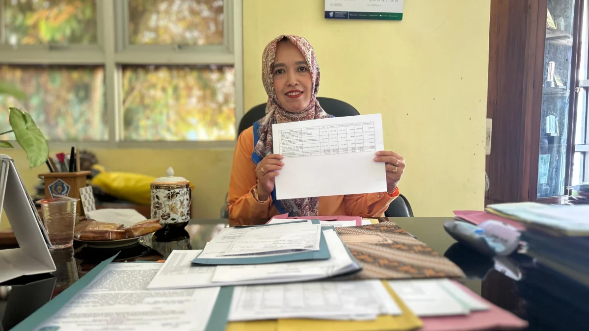 Kepala Dinsos P3A Kota Banjar, Hani Supartini, menunjukkan dokumen penerima bansos pada tahun 2023, di ruang kerjanya, Selasa (6/5/2025). (Cecep Herdi/Jabar Ekspres)