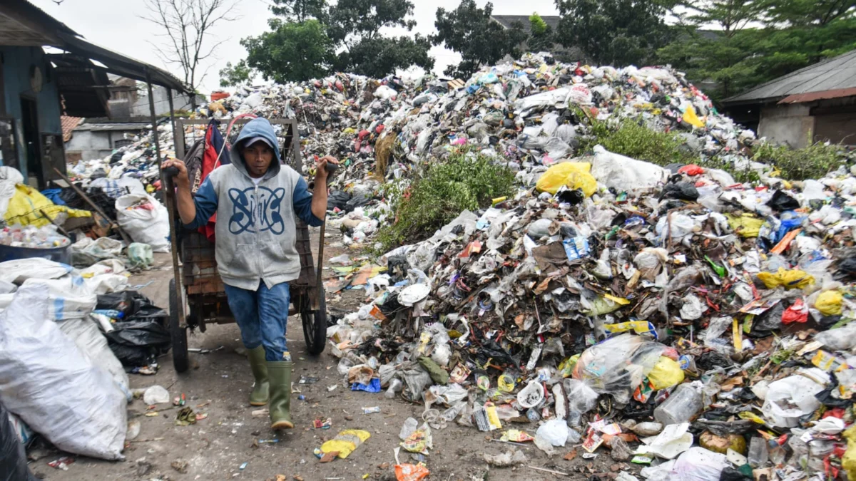Petugas membawa gerobak berisi sampah di dekat tumpukan sampah di Tempat Pembuangan Sampah Sementara (TPS) Pasar Ciwastra, Kota Bandung, Kamis (8/5). Foto: Dimas Rachmatsyah / Jabar Ekspres