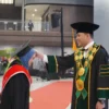 Rektor Unjani Prof. Dr. Agus Subagyo saat memindahkan kuncir toga salah satu wisudawati dalam prosesi wisuda periode I tahun akademik 2024–2025. (Mong / Jabar Ekspres)