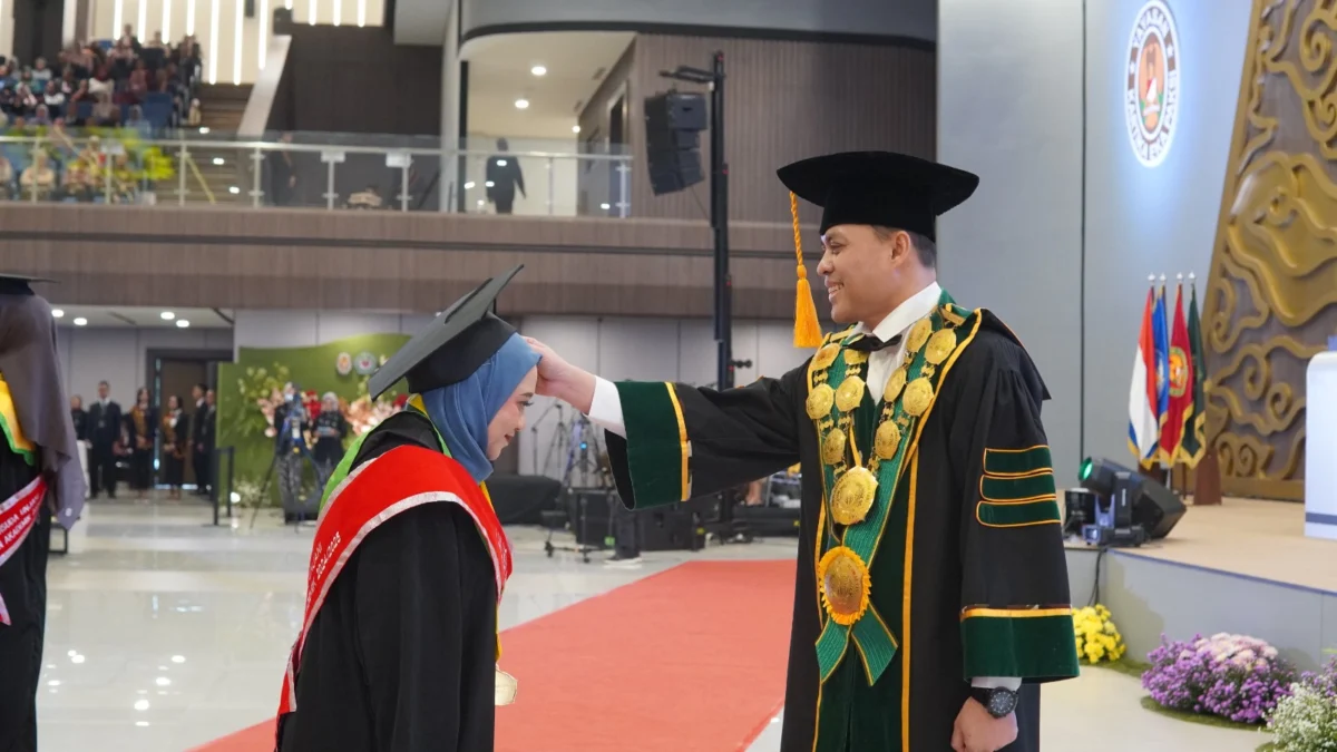 Rektor Unjani Prof. Dr. Agus Subagyo saat memindahkan kuncir toga salah satu wisudawati dalam prosesi wisuda periode I tahun akademik 2024–2025. (Mong / Jabar Ekspres)