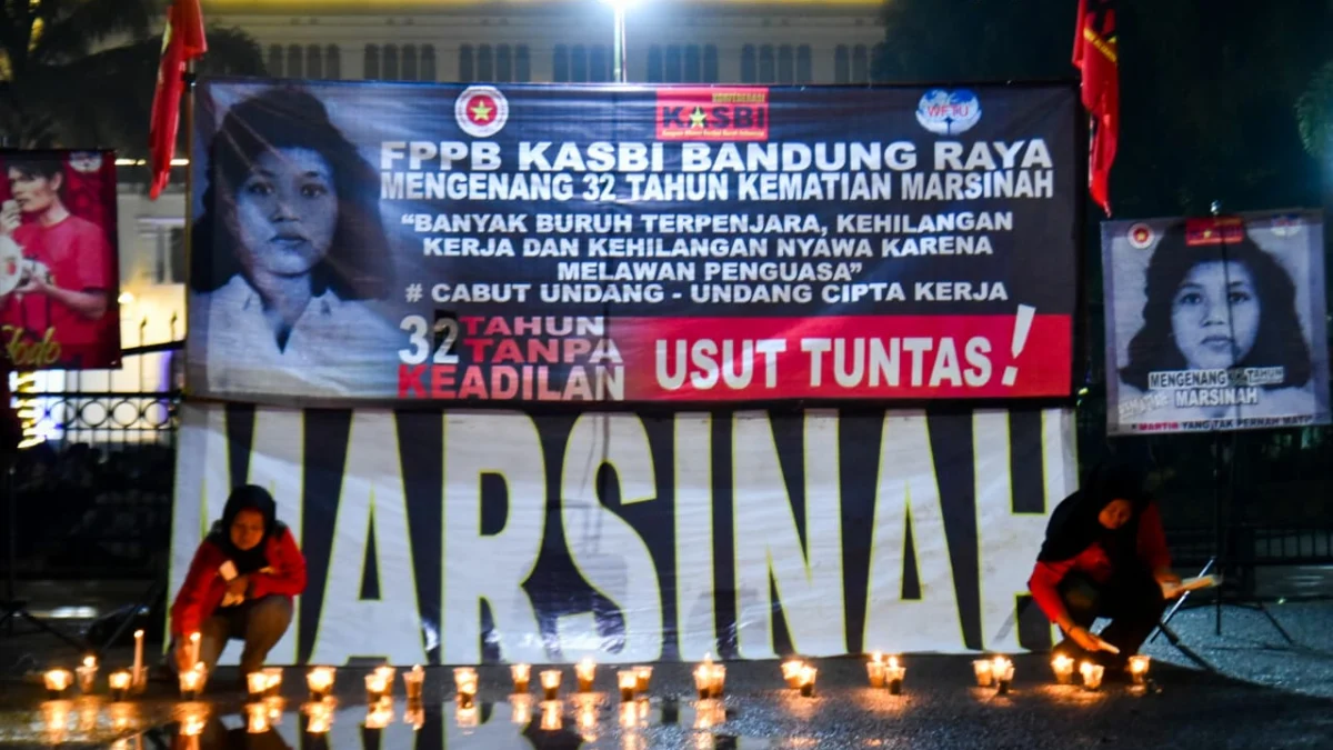 Sejumlah buruh dari Kongres Aliansi Serikat Buruh Indonesia (KASBI) Bandung Raya menyalakan lilin di depan tulisan dan foto Marsinah pada aksi mengenang 32 tahun kematian Marsinah di depan Gedung Sate, Kota Bandung, Kamis (8/5). Foto: Dimas Rachmatsyah / Jabar Ekspres