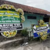 Suasana duka menyelimuti Desa Cinunuk, Kecamatan Cileunyi, Kabupaten Bandung, Selasa (13/5/2025), saat puluhan karangan bunga memenuhi jalan menuju rumah duka Mayor CPL Anda Rohana. Foto Agi