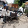 Warga melintas di dekat gerobak sampah yang akan diangkut kedalam TPS di dekat Pasar Ancol, Kota Bandung, Selasa (13/5). Foto: Dimas Rachmatsyah / Jabar Ekspres