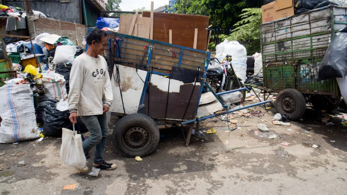 Warga melintas di dekat gerobak sampah yang akan diangkut kedalam TPS di dekat Pasar Ancol, Kota Bandung, Selasa (13/5). Foto: Dimas Rachmatsyah / Jabar Ekspres