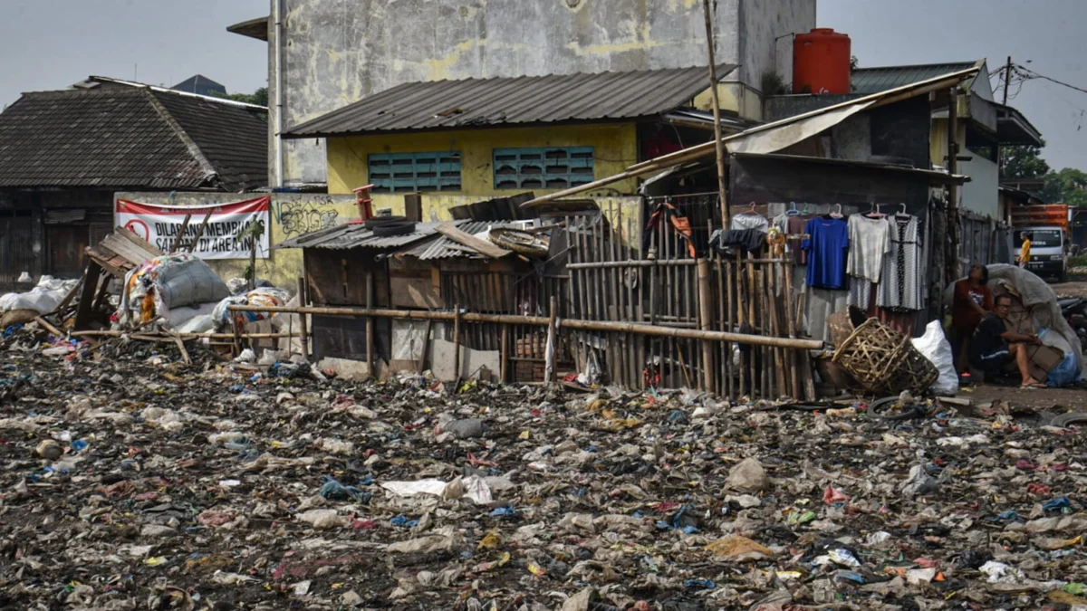 Ilustrasi: Warga berada di lahan bekas tumpukan sampah dan spanduk "Dilarang Membuang Sampah di Area Ini" di sekitar TPS Pasar Induk Gedebage beberapa waktu lalu. Foto: Dimas Rachmatsyah / Jabar Ekspres