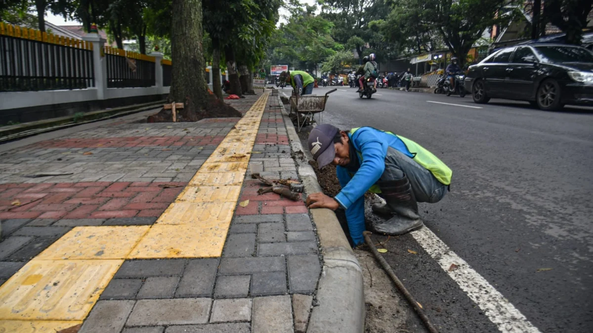 Pekerja menyelesaikan perbaikan fasilitas umum trotoar untuk penyandang disabilitas dan saluran air di Jalan Martanegara, Kota Bandung, Rabu (21/5). Foto: Dimas Rachmatsyah / Jabar Ekspres