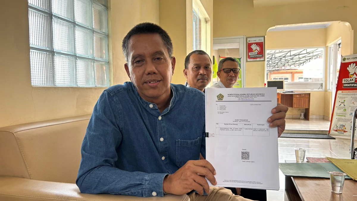 Kepala MAN 2 Ciamis, Aris Mujiraharjo menunjukkan dasar pungutan sumbangan siswa aaat diwawancara, Jumat (23/5/2025). (Cecep Herdi/Jabar Ekspres)