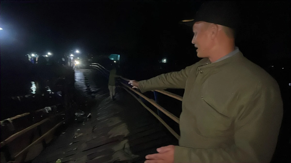 Kepala Desa (Kades) Bojongsari Asep Sunandar saat meninjau lokasi patahnya jembatan apung penghubung antara Kecamatan Bojongsoang dan Baleendah, Jumat (23/5) malam. Foto Agi