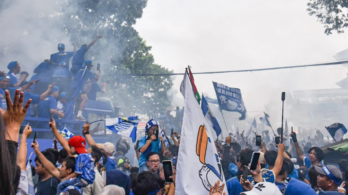 Bobotoh menonton konvoi perayaan juara liga 1 Persib Bandung di Jalan Wastukencana, Kota Bandung, Minggu (25/5). Foto: Dimas Rachmatsyah / Jabar Ekspres