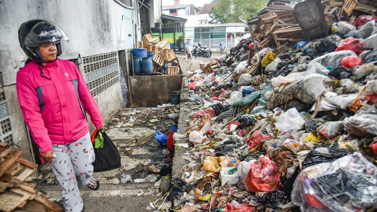Pembeli melintas di samping tumpukan sampah di TPS Pasar Kosambi, Kota Bandung, Sabtu (21/6). Foto: Dimas Rachmatsyah / Jabar Ekspres