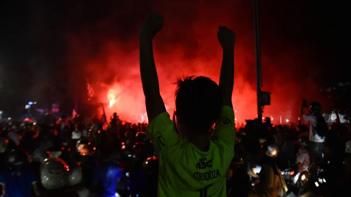 Nugraha Meninggal Dunia Usai Konvoi Persib, Jeje Ritchie Beri Santunan Seorang Bobotoh mengangkat tangan usai Persib Bandung memastikan gelar juara Liga 1 di Fly Over Mochtar Kusumaatmadja (Pasupati) Kota Bandung, Senin (5/5). Foto: Dimas Rachmatsyah / Jabar Ekspres