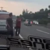 Ist. Tangkap layar video viral seorang pria saat mengacungkan benda mirip senpi kepada pengendara lain di Tol Cipularang. Dok istimewa