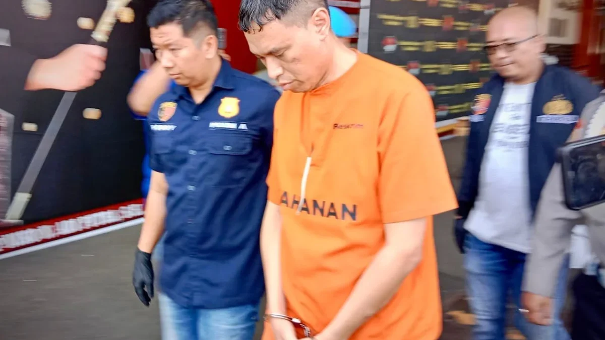 Tertunduk dan diborgol, Dirut BUMD PT PMgS, Deden Robby Firman digelandang polisi usai ditetapkan sebagai tersangka kasus cek kosong senilai Rp659 juta dalam proyek pengadaan ayam beku. Dok Jabar Ekspres/Mong