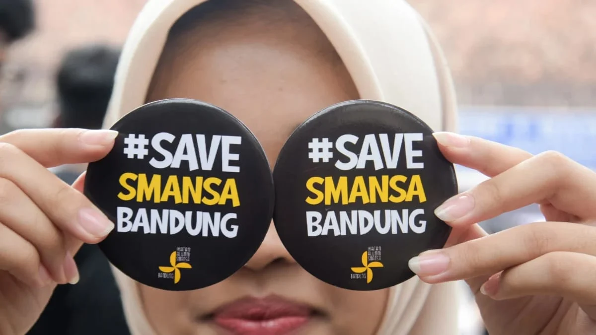 Ist. Seorang siswi menunjukan pin bertuliskan #SAVESMANSABANDUNG di halaman sekolah SMA Negeri 1, Kota Bandung, Senin (21/4). Foto: Dimas Rachmatsyah / Jabar Ekspres