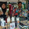 Anggi (bertopi) menunjukkan batik karyanya.