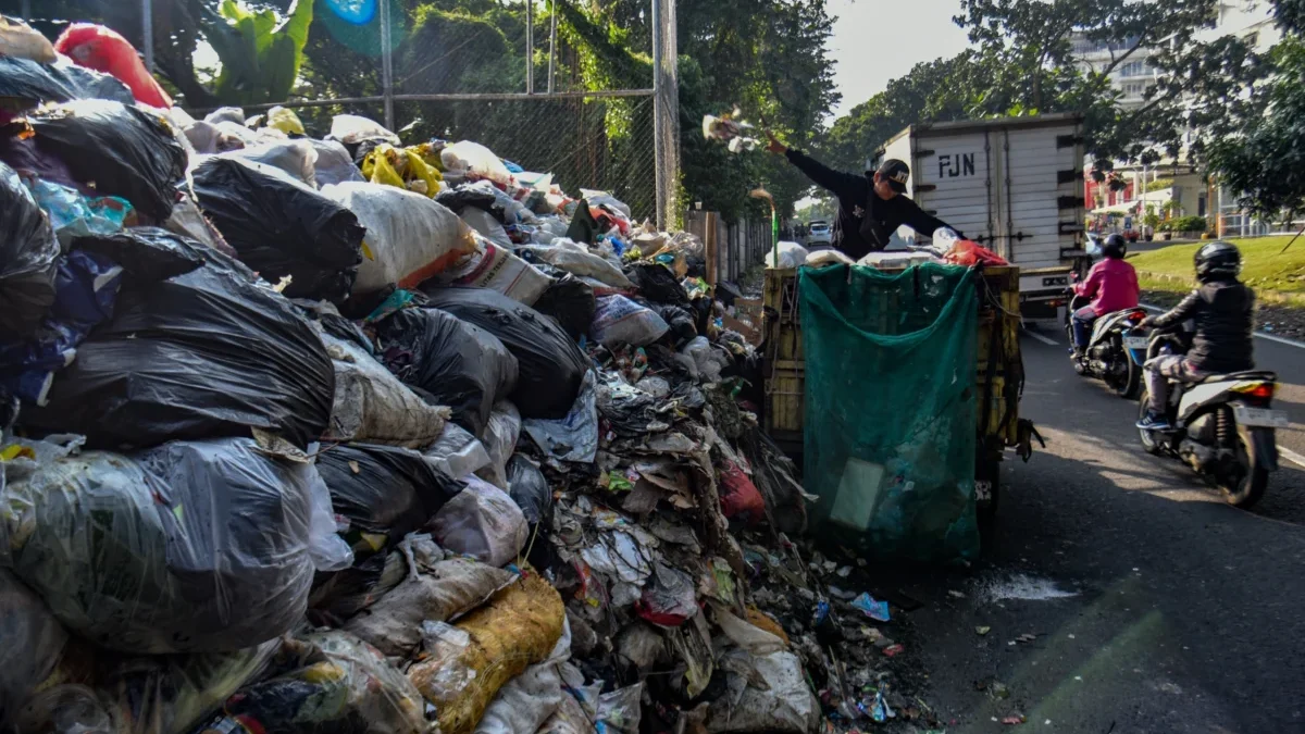 Sampah Menumpuk di TPS Gunung Batu, Pengangkutan Masih Tersendat Petugas membuang sampah di tumpukan sampah yang menjulang di Tempat Penampungan Sementara (TPS) Gunung Batu di Kelurahan Sukaraja, Kecamatan Cicendo, Kota Bandung, Jumat (13/6). Foto: Dimas Rachmatsyah / Jabar Ekspres
