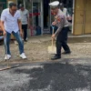 Kasat Lantas Polres Banjar AKP Firman Hidayat dan Kasat Reskrim Polres Banjar Iptu Heru Samsul Bahri turun memperbaiki jalan rusak di jalur Sinartanjung Kota Banjar, Rabu (18/6/2025). (Cecep Herdi/Jabar Ekspres)