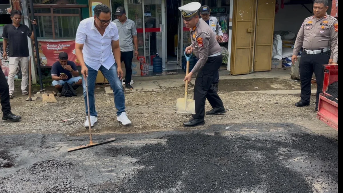 Kasat Lantas Polres Banjar AKP Firman Hidayat dan Kasat Reskrim Polres Banjar Iptu Heru Samsul Bahri turun memperbaiki jalan rusak di jalur Sinartanjung Kota Banjar, Rabu (18/6/2025). (Cecep Herdi/Jabar Ekspres)