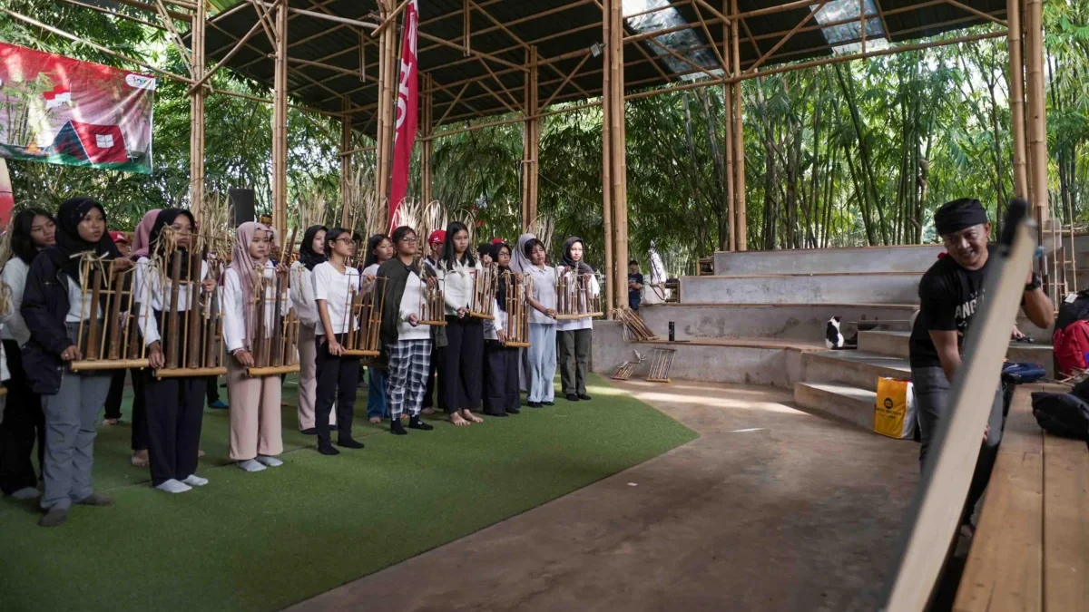 Peserta School Camp 2025 secara antusias menyaksikan proses pembuatan angklung di workshop Saung Angklung Udjo.