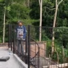 Petugas saat melakukan pemasangan pagar besi BRC di sebuah bangunan properti milik warga.
