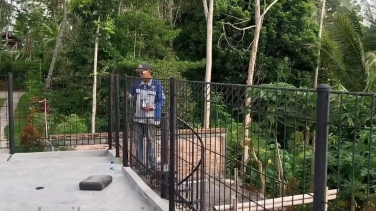 Petugas saat melakukan pemasangan pagar besi BRC di sebuah bangunan properti milik warga.