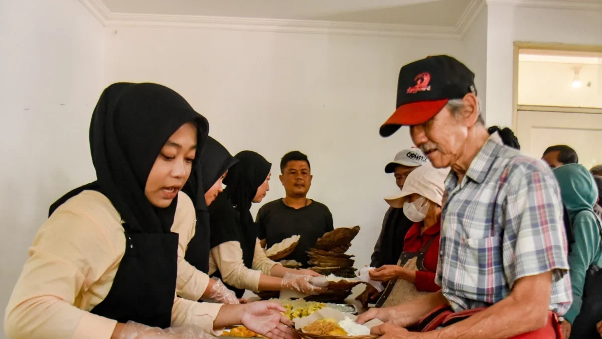 Petugas memberikan makanan kepada warga di Warung Makan Gratis Bunda di Jalan Progo, Kota Bandung, baru-baru ini. Foto: Dimas Rachmatsyah / Jabar Ekspres