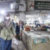 Warga berjalan membawa belanjaan menggunakan kantong plastik di dekat poster imbauan kurangi penggunaan plastik di Pasar Kosambi, Jalan Ahmad Yani, Kota Bandung, Jumat (11/7). Foto: Dimas Rachmatsyah / Jabar Ekspres
